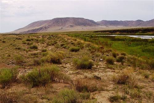 Aerial view of Colorado Costilla County 0.25-acre Rio Grande River lot 327, showing surrounding natural landscape and river access.
