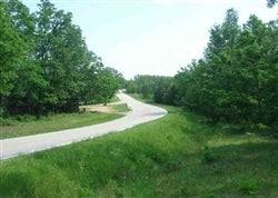 Aerial view of Missouri Dent County Deer Valley Lot 8, a 10.12-acre rural property with wooded landscape and open areas.