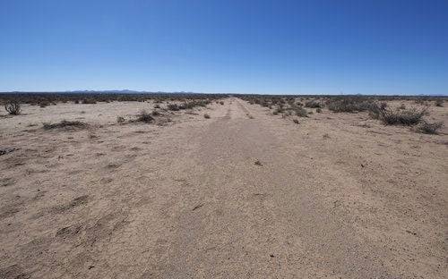 Aerial view of New Mexico Luna County Deming Ranchettes Lot 25 and 26, 1-acre parcels with open desert landscape and clear blue sky.