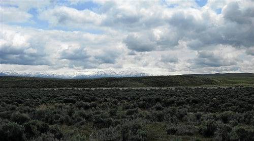 A scenic view of Meadow Valley Ranchos land in Elko County, Nevada, showcasing open grassy fields and surrounding mountains.