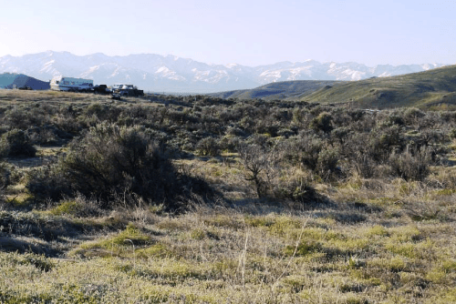 Aerial view of Nevada Elko County Twin River Ranchos Lot 03 Unit 4, showing open land with nearby power lines and rural landscape.
