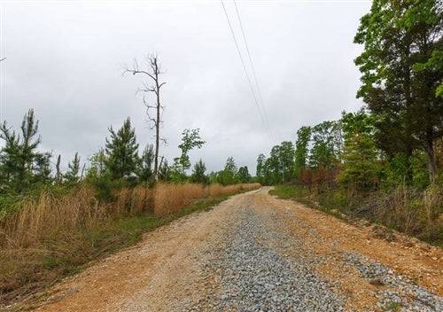 Aerial view of Tennessee Benton County Red Barn Ranch lot 37 with a red barn, stream, and surrounding rural landscape.
