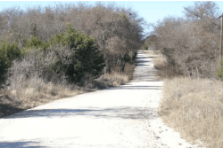 Aerial view of Texas Hill County Bear Creek Estates Lot 39, a .12-acre property with natural landscape and trees.