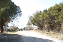 Aerial view of Texas Hill County Lake Whitney Estates, Unit 2 Lot 412 showing a 0.11-acre land parcel with surrounding natural landscape.