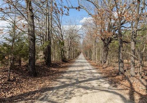 Aerial view of Wishing Star Ranch Lot 39 in Red River County, Texas, showing lush land and a nearby stream.