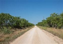 Aerial view of Texas McCulloch County Hunters Ranch Lot 15, showing wooded land and open fields in a rural landscape.