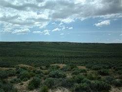 Aerial view of Wyoming Sweetwater County 40-acre land parcel near Rawlins, showcasing open grassy terrain and surrounding landscape.