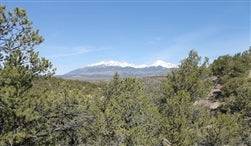 A scenic view of Colorado's Alamosa County with a 5.06-acre Sangre De Cristo Ranches property, featuring open land and mountain views.