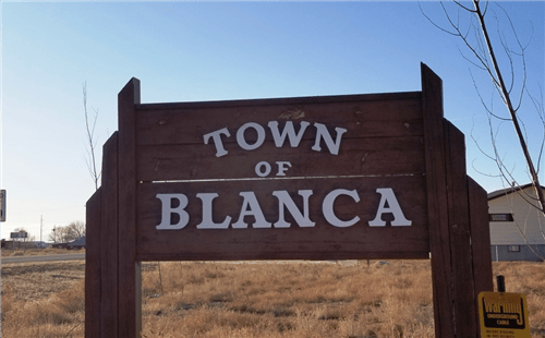 Aerial view of Colorado Costilla County lot, 0.16 acres in Blanca with clear land, trees, and surrounding rural scenery.