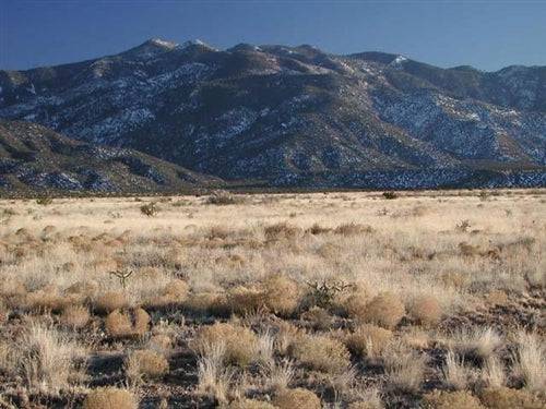 Aerial view of Valencia County, New Mexico, showing a 0.25-acre Rio Del Oro lot 6 with surrounding landscape and nearby properties.