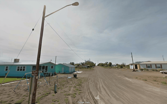 Aerial view of Colorado Alamosa County 0.32-acre Hooper Block 10, Lots 22-26 with open land and nearby electrical infrastructure.