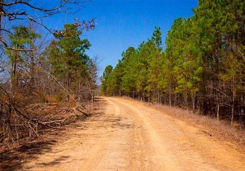 Aerial view of Oklahoma Latimer County 4.27-acre Stone Creek Phase II lot 126 featuring a stream and wooded landscape.