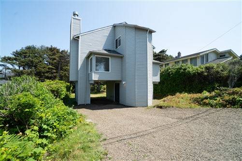 Beach house rental deposit at Oregon Sea Base, showing a cozy coastal home with ocean views and lush surroundings.