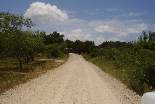 Aerial view of Lot 850 in Shamrock Shores, Lake Brownwood, Texas, showing wooded land with nearby lake access and electrical hookup.