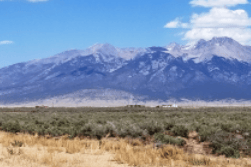Aerial view of Colorado Alamosa County 1.01-acre Deer Valley Meadows Lot 1 in Unit 2, Block G, with scenic landscape and open land.