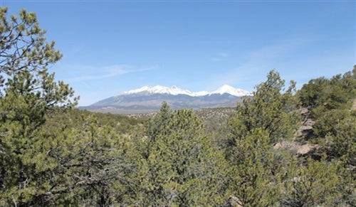 Aerial view of 5.22-acre Colorado land in Costilla County's Sangre De Cristo Ranches, with open grassy terrain and mountain backdrop.