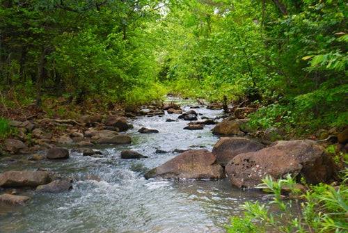 9.94-acre creek lot with cabin, electricity, and lake view in Pushmataha County, Oklahoma, ideal for ranch or outdoor living.